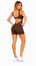 Woman wearing a brown cut-out sports outfit on a white background