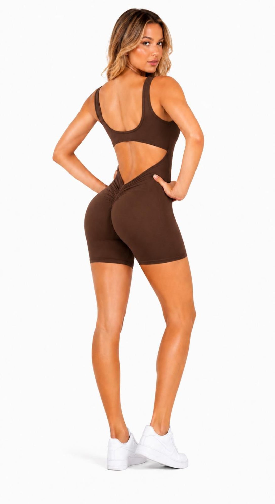 Woman wearing a brown cut-out sports outfit on a white background